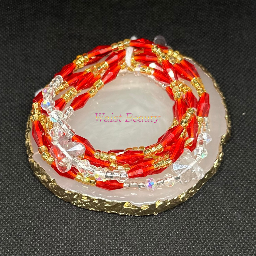 A stunning waist bead featuring red, gold, and clear beads, adding a touch of elegance and sophistication to any outfit.