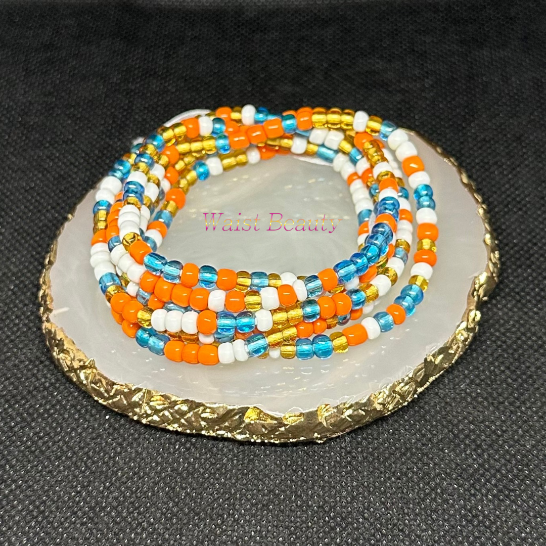 A waist bead featuring vibrant orange, blue, gold, and white beads arranged in a stylish pattern.