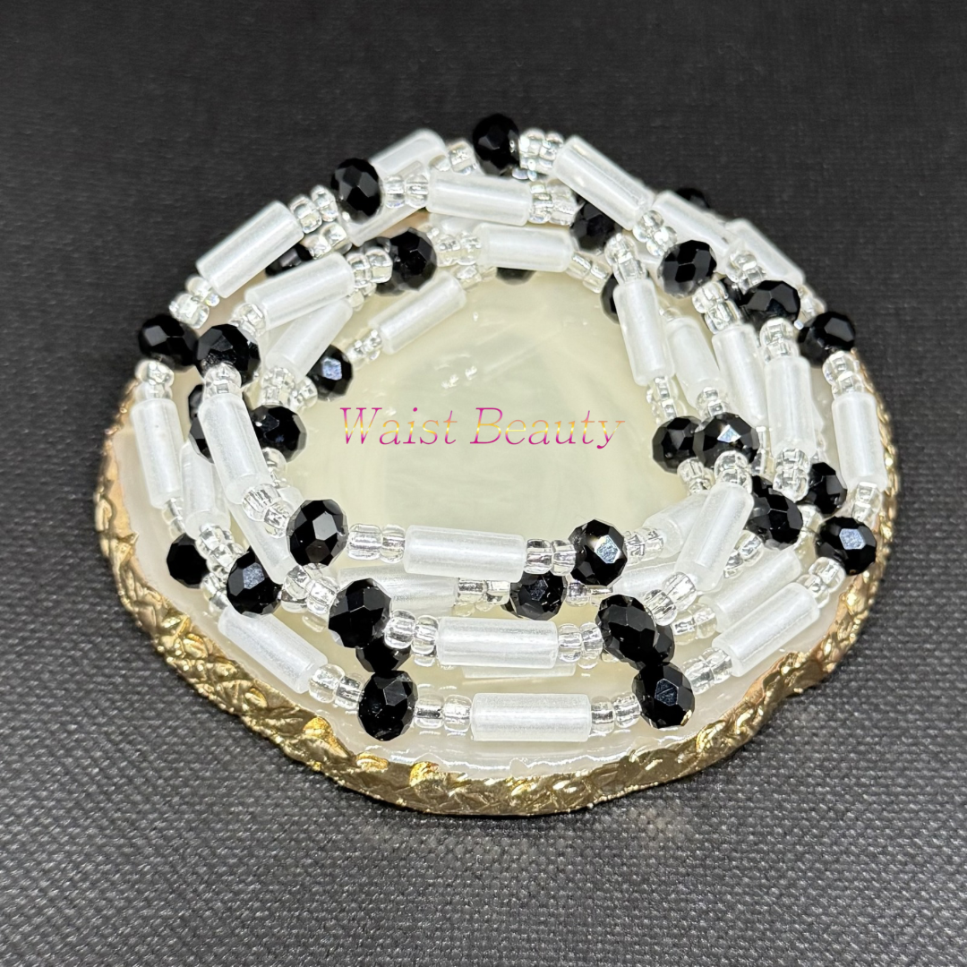 Waist Beauty - Bold, timeless, and completely effortlessly chic. The Midnight Onyx tie-on waist beads offer a powerful high-contrast look featuring frosted white glass cylinders paired with mesmerizing, light-catching faceted black crystals. Strung together on crisp silver-lined seed beads, this monochromatic masterpiece represents ultimate protection, elegance, and inner power. At 53 inches, it’s the ultimate sleek accessory to wear all year round.