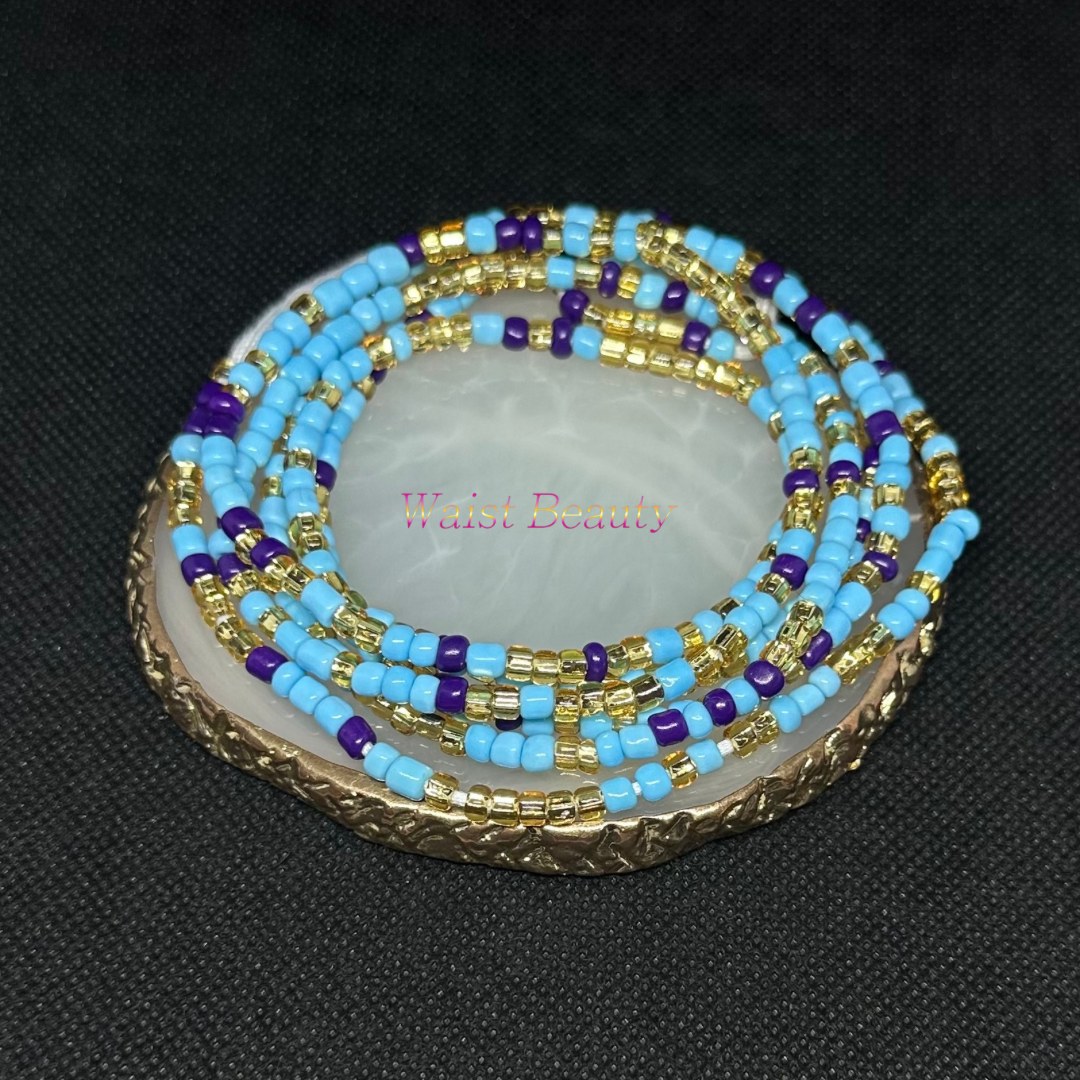A close-up image of a tie-on waist bead with light blue, purple, and gold beads, arranged in a stylish pattern.