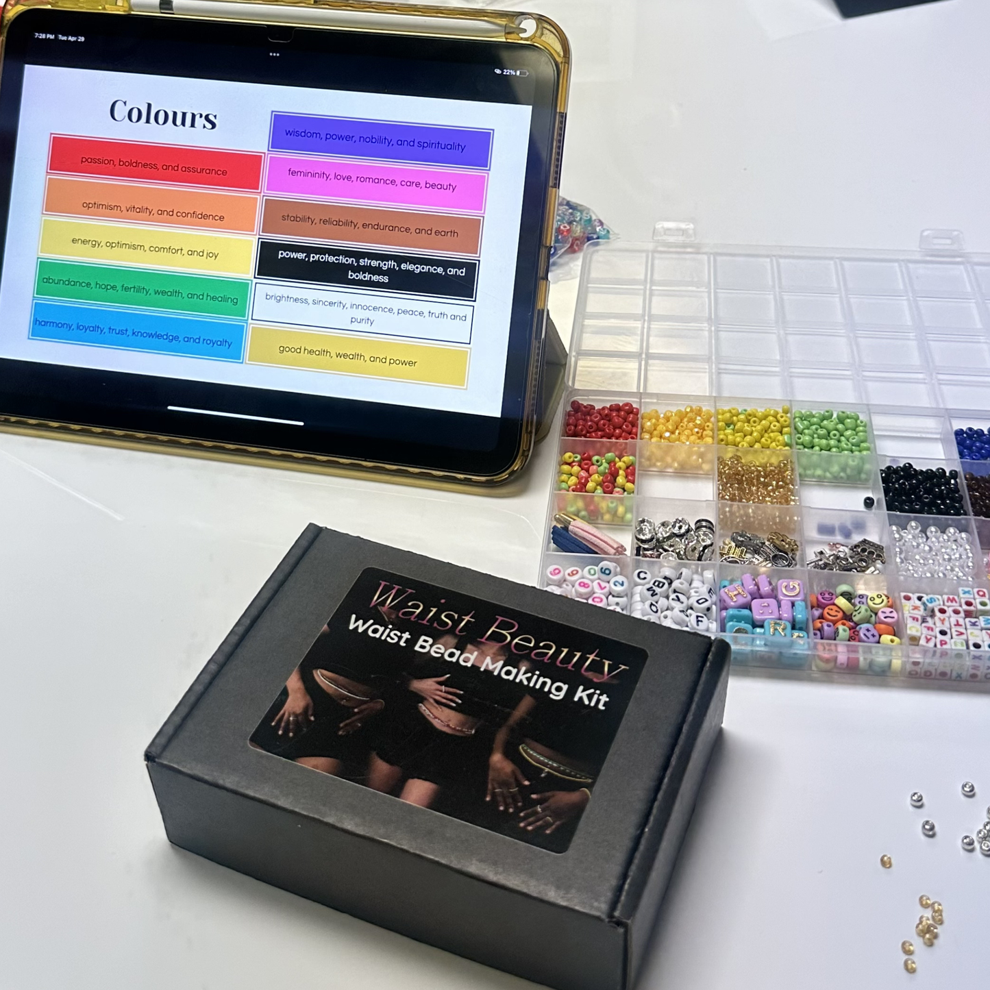 Waist Beauty waist bead making kit with beads and a tablet displaying color chart on a white surface.