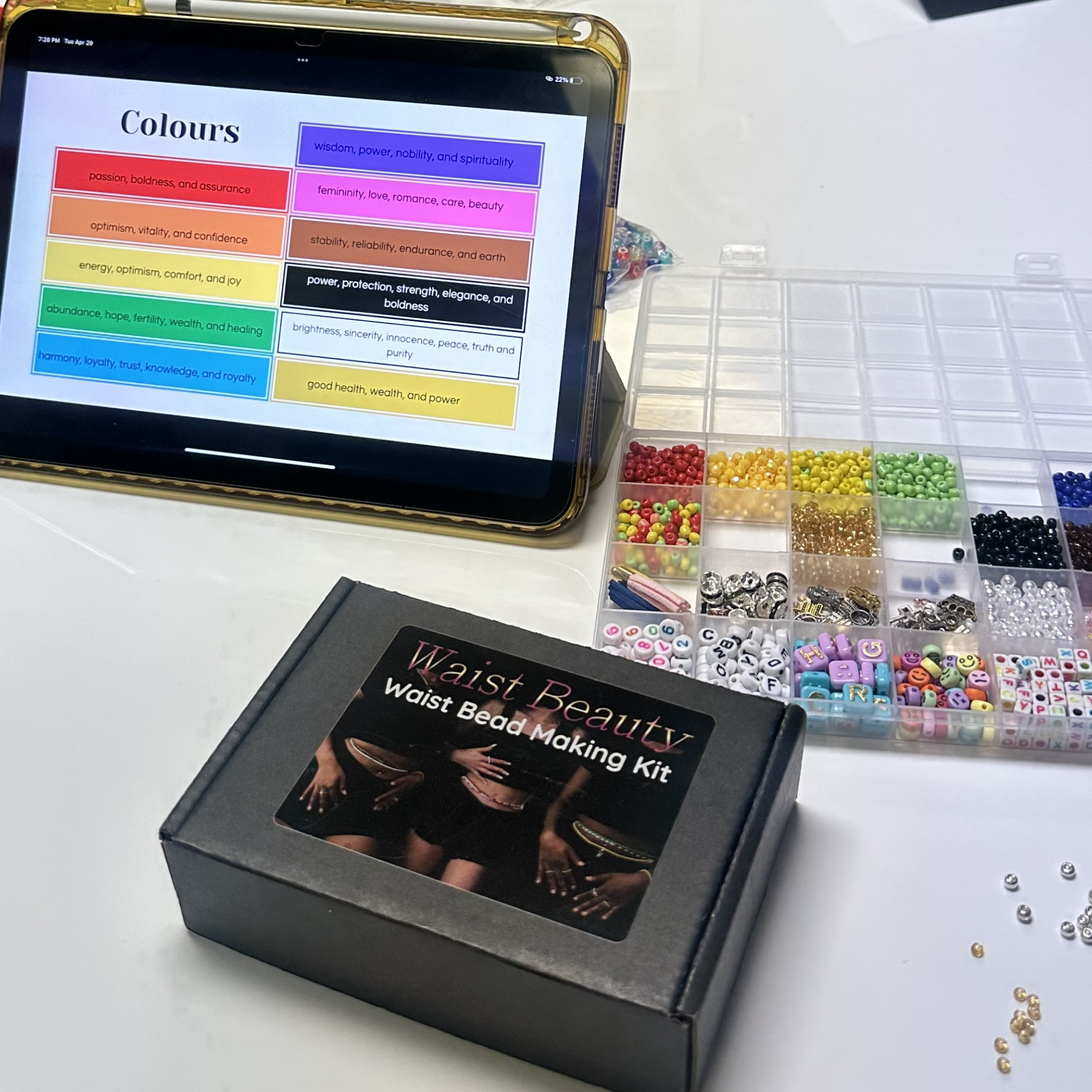 Waist Beauty waist bead making kit with beads and a tablet displaying color chart on a white surface.