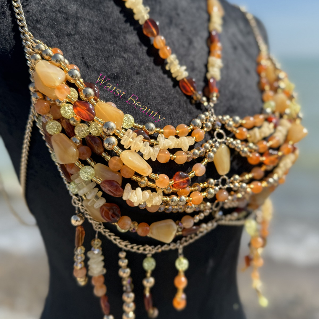 Waist Beauty - Golden hour goddess top featuring bohemian gold chains and amber stone beads on a black mannequin by the ocean.