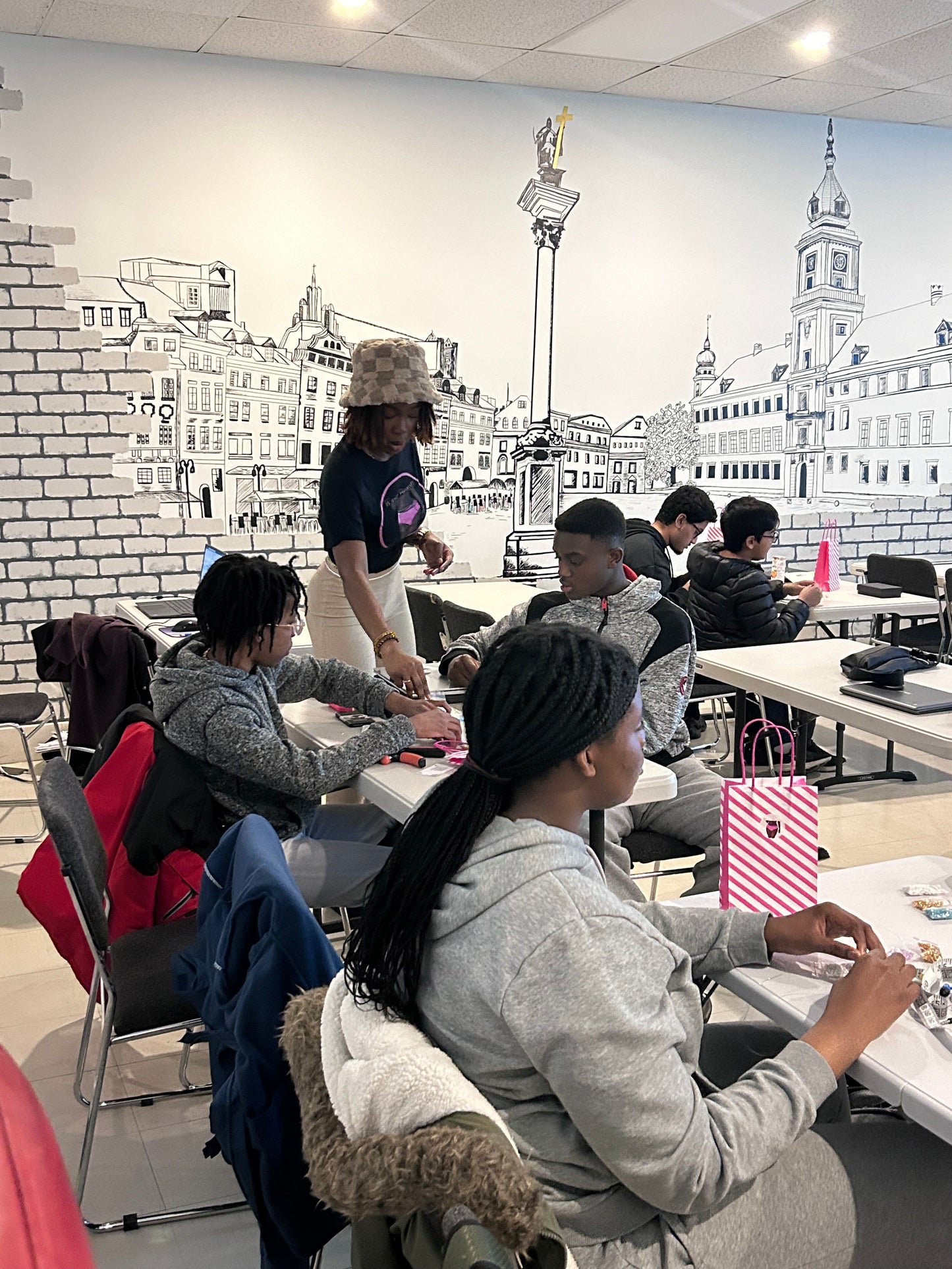 Students in a classroom learning how to bead