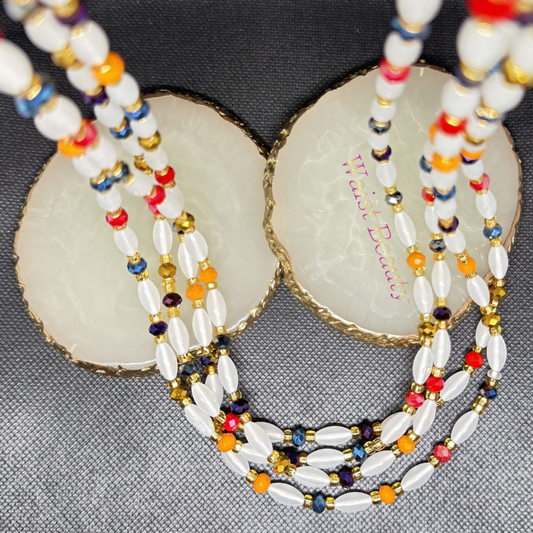 “Tie-on waist bead strand featuring opalescent rice-shaped beads, multicoloured crystal rondelles, and metallic gold seed beads. The 53-inch design reflects rainbow-like light and layers easily for a vibrant, radiant look.”