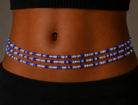 A close-up of a person's waist wearing a beaded belly band with alternating royal blue and clear faceted beads, paired with a black ribbed top and black bottoms.